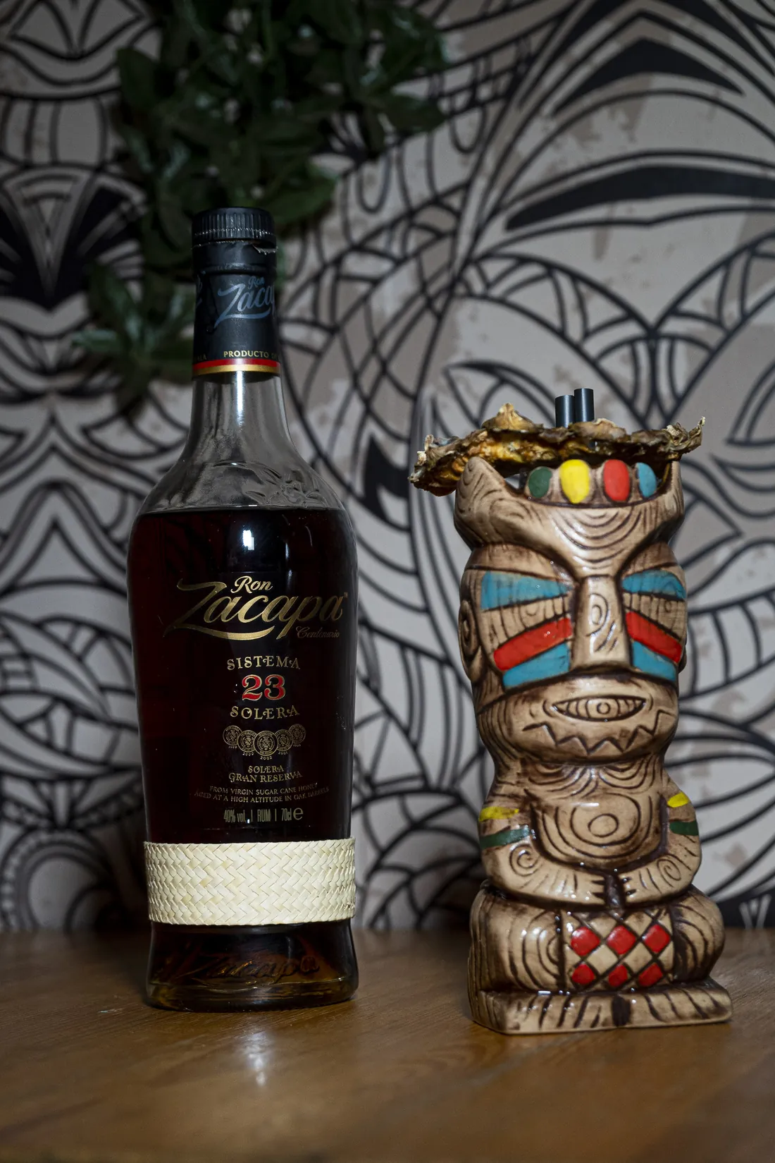 Botella de ron añejo junto a un vaso tiki en la barra de Hanalei
